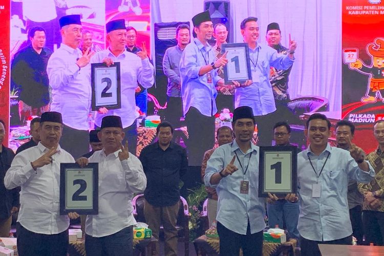 Pasangan calon bupati dan wakil bupati, Ahmad Dawami Ragil Saputro-Sandhika Feryantiko (Madiun Menyala) menunjukkan hasil undian nomor 1 dan Hari Wuryanto-Purnomo Hadi (Harmonis) memperoleh nomor urut 2 pada pengundian nomor urut pemilihan kepala daerah dan wakil kepala daerah (pilkada) 2024 di Kantor KPU Kabupaten  Madiun, Senin (23/9/2024) malam.