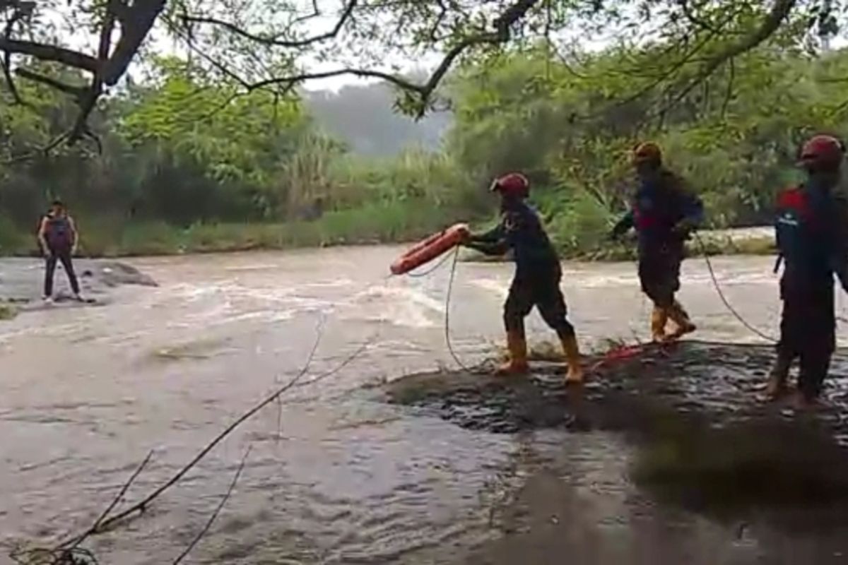 Petugas pemadam kebakaran (damkar) menyelamatkan dua bocah SMP yang terjebak di batu antara aliran Sungai Ciliwung, Desa Pasir Jambu, Kecamatan Sukaraja, Kabupaten Bogor, Jawa Barat, Senin (13/2/2023) petang. Kedua bocah laki-laki berinisial SF (14) dan JP (13) itu terjebak saat sedang berenang bersama teman-temannya sesuai pulang sekolah.