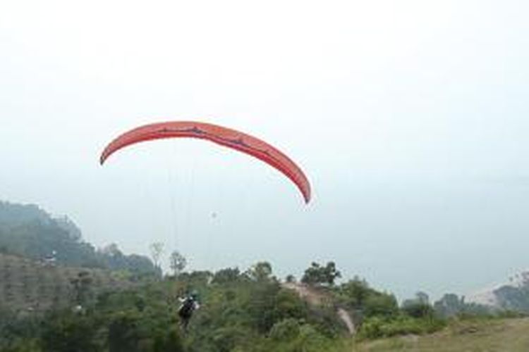 Anggota Langkisau Paralayang Club dari Bukit Langkisau menuju pendaratan di Pantai Salido, Sumatera Barat.
