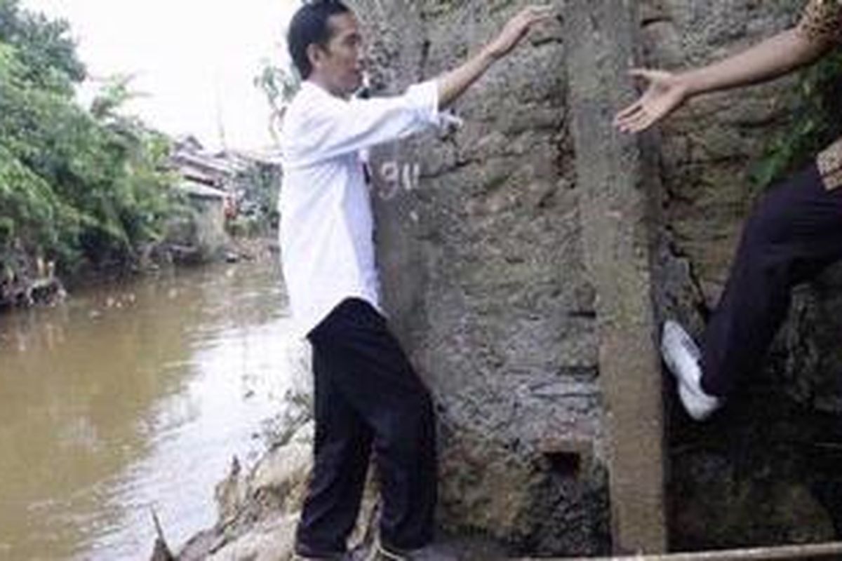Gubernur DKI Jakarta, Joko Widodo memerhatikan bantaran Ciliwung di Kawasan Bukit duri, Jakarta Selatan,  Selasa (16/10/2012). Sehari setelah dilantik, gubernur baru Jakarta tersebut langsung mengunjungi kawasan padat penduduk dan bantaran Ciliwung. 