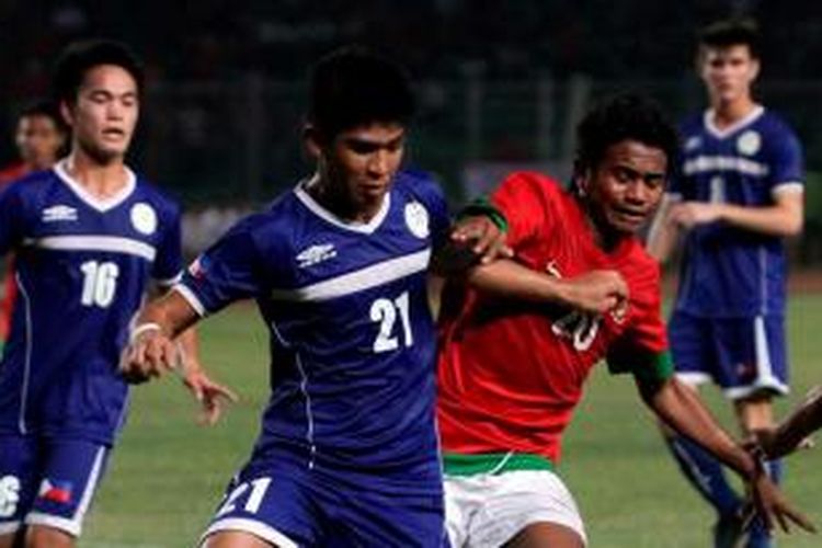 Pemain Indonesia Ilham Udin Armaiyn (merah) berusaha melewati pertahanan Filipina dalam pertandingan kualifikasi Piala Asia U-19 di Stadion Utama Gelora Bung Karno, Jakarta, Kamis (10/10/2013). Timnas Indonesia mengalahkan Filipina 2-0.