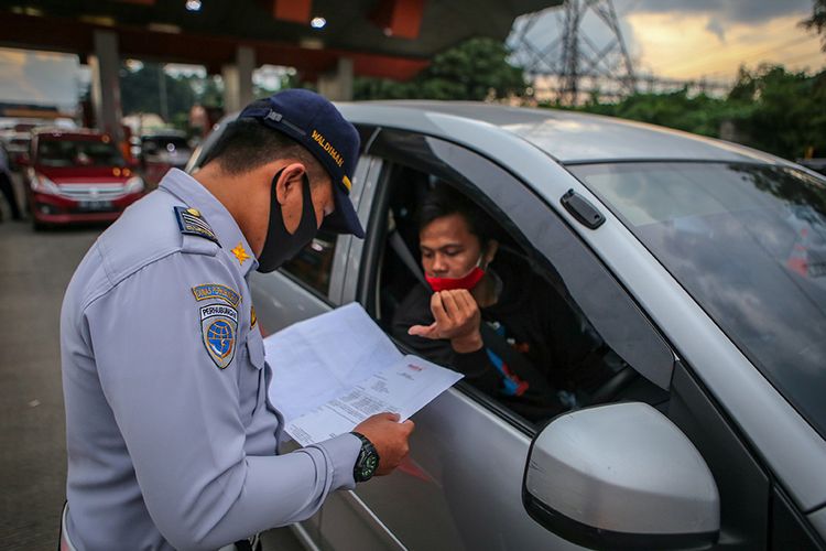 Petugas memeriksa kendaraan di gerbang tol Cikupa, Kabupaten Tangerang, Banten, Rabu (27/5/2020). Petugas memutarbalikkan kendaraan menuju Jakarta yang tidak dilengkapi surat izin keluar masuk (SIKM) Jakarta dalam upaya pencegahan penularan Covid-19 sesuai Pergub DKI Jakarta Nomor 47 Tahun 2020.