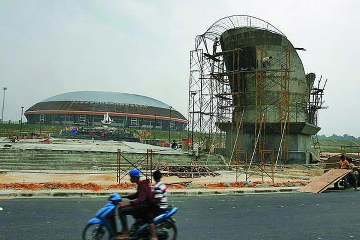 Pekerja di proyek pembangunan arena PON XVIII/2012 di Pekanbaru, Riau, mengerjakan pembangunan gapura di Kompleks Stadion Utama Universitas Riau. PON dibuka pada tanggal 11 September 2012, tetapi banyak pembangunan arena belum rampung.