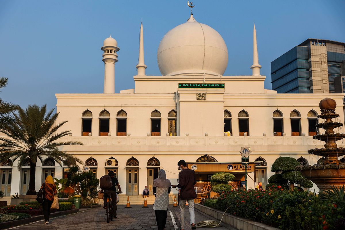 Pengurus masjid Al Azhar membagikan takjil atau hidangan berbuka puasa kepada warga secara Drive Thru di Jakarta, Senin (26/4/2021). Buka bersama melalui drive-thru dilakukan untuk mencegah penularan Covid-19 yang bisa terjadi bila berkerumun.