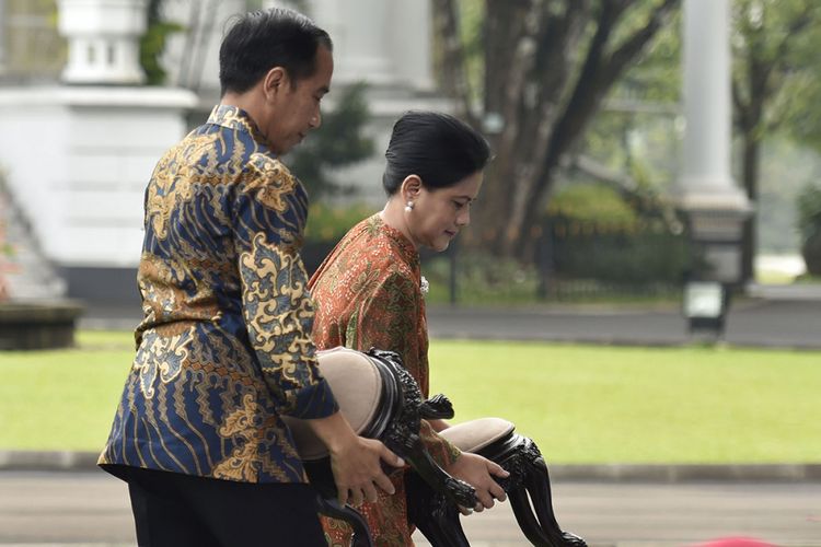 Presiden Joko Widodo (kiri) bersama Ibu Negara Iriana Joko Widodo mengangkat kursi untuk menyaksikan pertunjukan sulap bersama anak-anak penderita kanker pendampingan Yayasan Kanker Anak Indonesia di halaman belakang Istana Bogor, Jawa Barat, Jumat (6/4/2018). Yayasan Kanker Anak Indonesia dalam kesempatan tersebut meminta regulasi impor obat kanker dipermudah dan bea masuk ditiadakan.