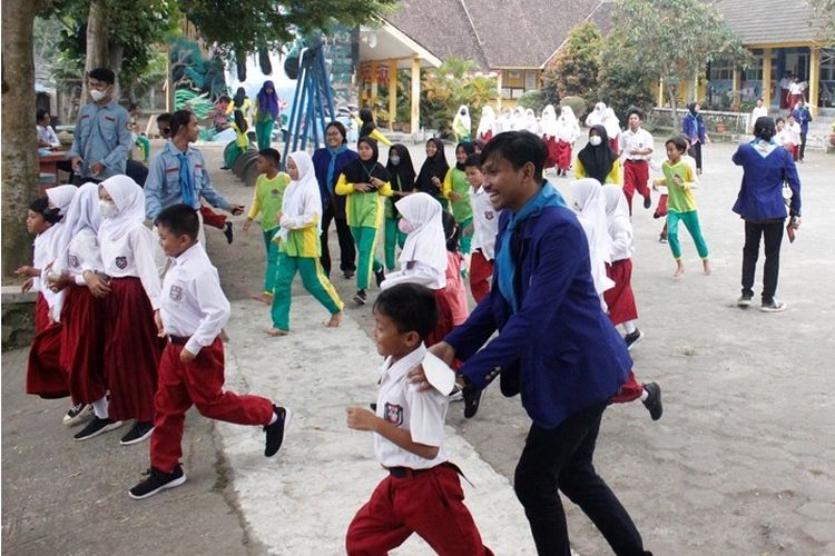 Mahasiswa Universitas Negeri Yogyakarta (UNY) mengajarkan anak SD simulasi bencana. 