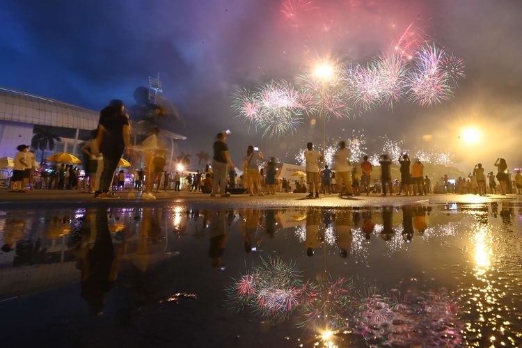 Sejumlah warga menyaksikan pertunjukan kembang api pada upacara pembukaan SEA Games 2021 Vietnam dari luar Stadion Nasional My Dinh, Hanoi, Kamis (12/5/2022). Ajang olah raga dua tahunan Asia Tenggara tersebut berlangsung hingga 23 Mei 2022 dengan mempertandingkan 40 cabang olah raga dan diikuti oleh kontingen dari 11 negara. ANTARA FOTO/Aditya Pradana Putra/YU