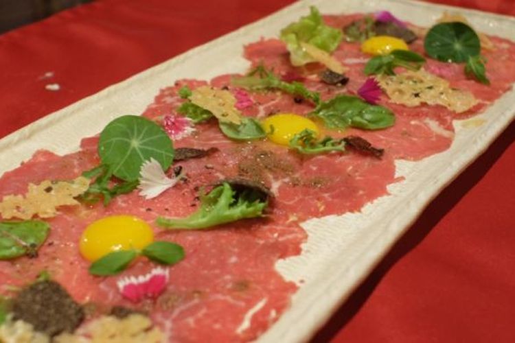 Carpaccio di Wagyu. Daging wagyu dengan telur burung puyuh, truffle hitam, dan tanaman herb.