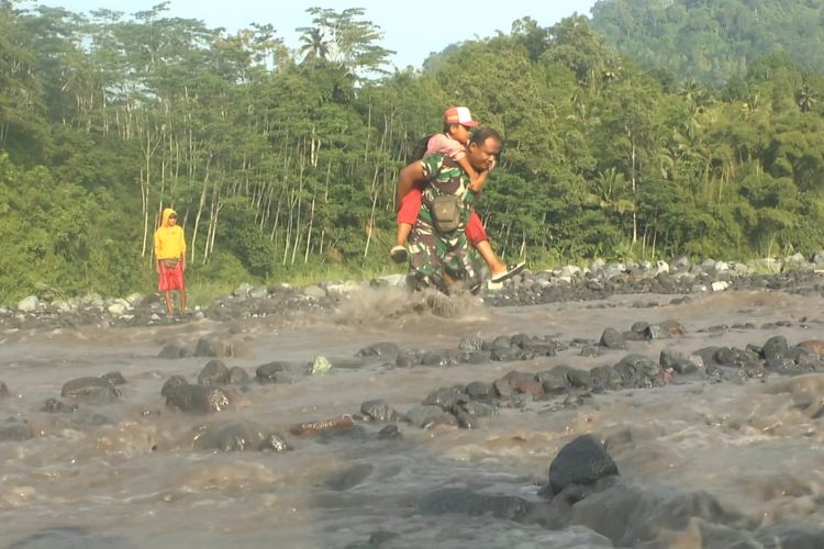 Babinsa Gendong siswa sebrangi banjir lahar Gunung Semeru untuk pergi sekolah, Kamis (10/4/2025)