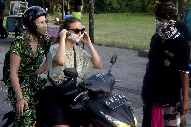 Foto dirilis Jumat (22/5/2020), memperlihatkan pecalang meminta wisatawan mancanegara untuk mengenakan masker sebagai upaya pencegahan penyebaran COVID-19 di wilayah Desa Adat Jimbaran, Badung.