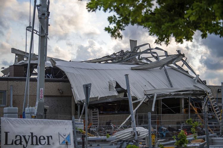 Atap dealer mesin konstruksi terletak di seberang gedung dari cuaca buruk di Paderborn, Jerman, Jumat, 20 Mei 2022.