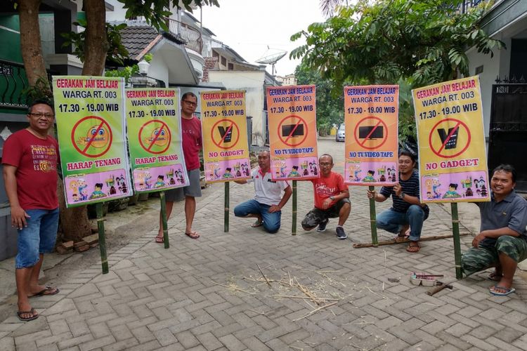 Warga RT 03/ RW 08 Perumahan Taman Kampus, Kelurahan Tegal Gede, Kecamatan Sumbersari, Kabupaten Jember, Jawa Timur, memasang spanduk gerakan jam belajar.