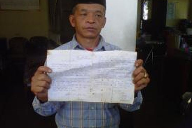 Slamet Rohmadi, menunjukkan surat tertulis dari anaknya, Rihanatun, yang menjadi TKW di Malaysia, Senin (18/8/2014).