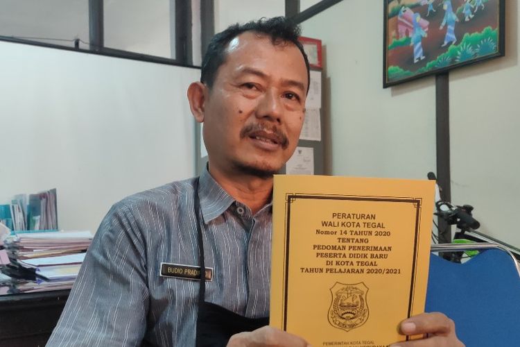 Kepala Bidang Pendidikan Dasar Disdikbud Kota Tegal, Jawa Tengah,  Budio Pradipto menunjukan buku Perwal tentang pedoman PPDB tahun pelajaran 2020/2021 di kantornya, Selasa (16/6/2020)