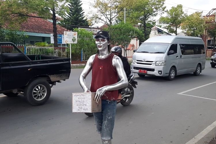 Giarto (27) seorang manusia silver yang mencari uang di persimpangan jalan Jenderal Ahmad Yani, Blora, Selasa (16/11/2021)