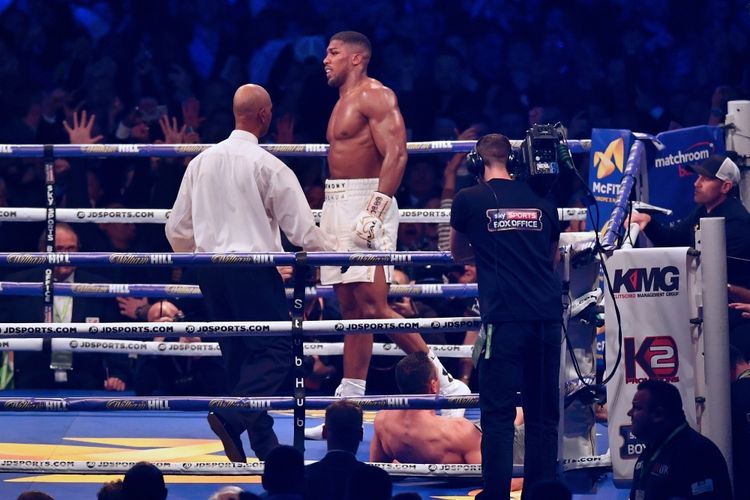 Petinju Inggris, Anthony Joshua (tengah), berjalan menjauhi petinju Ukraina, Wladimir Klitschko, yang terjatuh terkena pukulannya pada ronde ke-11 pertarungan kelas berat di Wembley Stadium, London, Sabtu (29/4/2017).