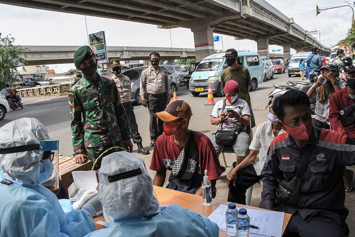 Sejumlah warga yang terjaring razia protokol kesehatan mengikuti rapid test oleh petugas medis di Kalimalang, Bekasi, Jawa Barat, Selasa (29/12/2020). Tim Gabungan dari TNI, Polri dan Satpol PP melakukan rapid test  kepada warga yang terjaring razia protokol kesehatan untuk mencegah penyebaran wabah COVID-19.