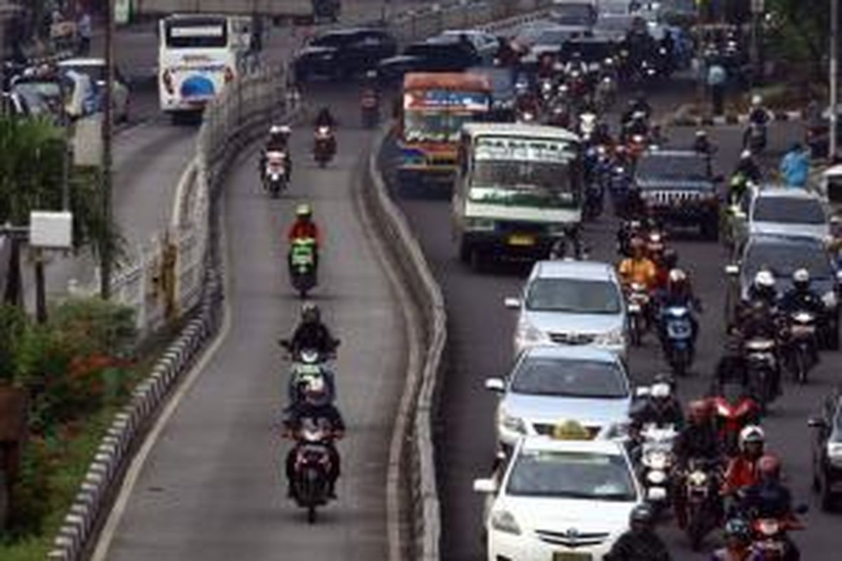 Pengendara melintas di jalur bus Tansjakarta di Kawasan Mampang, Jakarta Selatan, Selasa (29/10/2013). Dirlantas Polda Metro Jaya akan menerapkan denda bagi pengendara yang menerobos jalur bus yaitu Rp 1 juta bagi mobil dan Rp 500.000 bagi pengendara motor.