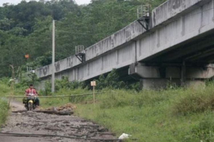 Jalan retak di bawah jembatan rel kereta api di Kampung Cisuren, Desa Mekargalih, Kecamatan Jatiluhur, Minggu (12/3/2017). 