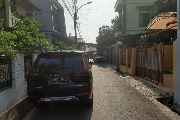 Parkir mobil di pinggir jalan kompleks perumahan 