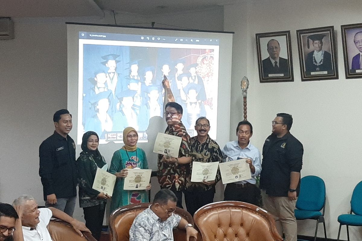 Sejumlah Alumni Fakultas Kehutanan UGM angkatan 1980 yang dahulu berfoto bersama dengan Presiden Joko Widodo saat diwisuda saat menunjukan ijazah. Mereka berdiri di depan layar besar yang menampilkan satu foto bersama Presiden Joko Widodo saat wisuda. Salah satu alumni, tampak menunjukan posisi Presiden Joko Widodo di foto tersebut.