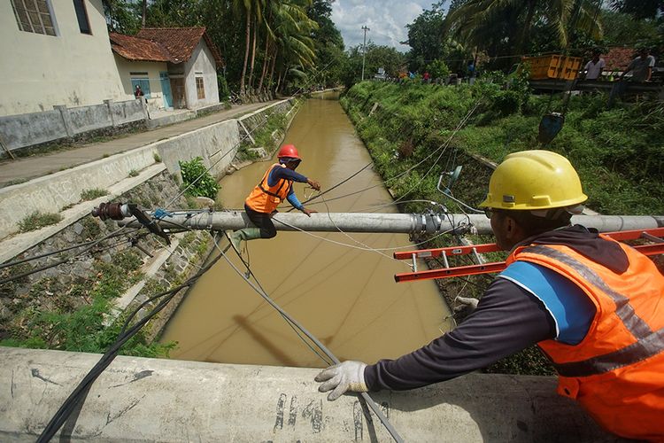 Petugas PLN memperbaiki tiang listrik yang roboh pascabencana hidrometeorologi (bencana angin kencang dan hujan) di Sendangrejo, Minggir, Sleman, Daerah Istimewa Yogyakarta (DIY), Senin (9/12/2019). Bencana hidrometeorologi yang terjadi pada Minggu (8/12/2019) menyebabkan ratusan pohon tumbang, puluhan rumah rusak dan sejumlah jaringan listrik rusak di DIY. Tidak ada korban jiwa dalam peristiwa tersebut.