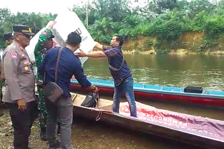 TNI dan Polisi menyeberangi sungai menggunakan perahu getek saat mengawal distribusi logsitik pemilu di dusun Sri Pengantin di Desa Pasenan, Kecamatan Suku Tengah Lakitan (STL) Ulu Terawas, Kabupaten Musi Rawas, Sumatera Selatan, Selasa (13/2/2024).