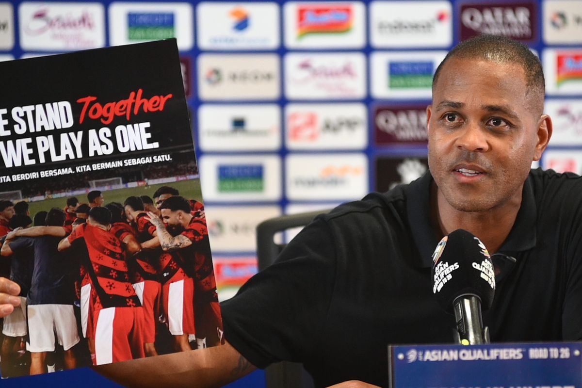 Pelatih Timnas Indonesia Patrick Kluivert dalam konferensi pers usai mengalahkan China, Kamis (5/6/2025) di Stadion Utama Gelora Bung Karno, Senayan, Jakarta. Ia memperlihatkan poster bertuliskan ?We stand together, we play as one?.