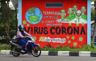 Seorang pengendara motor melintas di depan mural tentang pandemi COVID-19 di Pontianak, Kalimantan Barat, Kamis (29/4/2021). Mural yang dibuat oleh warga setempat itu untuk memberikan dukungan atas perjuangan tim medis yang selama ini berada di garis terdepan dalam penanganan COVID-19 khususnya di Pontianak. ANTARA FOTO/Jessica Helena Wuysang/wsj.