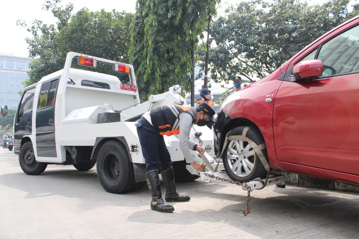 Petugas Suku Dinas Perhubungan Jakarta Utara sedang melakukan penderekan terhadap mobil yang dianggap melanggar karena parkir sembarangan dalam Operasi Lintas Jaya, Selasa (17/5/2022).