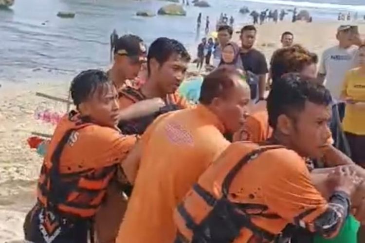 Petugas Satlinmas mengevakuasi korban terseret ombak di pantai Watulawang, Gunungkidul. Korban didaratkan di Pantai Ngandong, setelah sebelumnya dievakuasi menggunakan perahu. Minggu (5/5/2024)