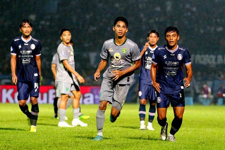 Pemain muda Persebaya Surabaya Marselino Ferdinan (tengah) dijaga ketat pemain Arema FC Irsyad Maulana saat pertandingan pekan ke-11 Liga 1 2022-2023 yang berakhir dengan skor 2-3 di Stadion Kanjuruhan Kepanjen, Kabupaten Malang, Sabtu (1/10/2022) malam. Artikel ini berisi link live streaming Dewa United vs Arema FC dalam lanjutan pekan ke-12 Liga 1 2022-23.