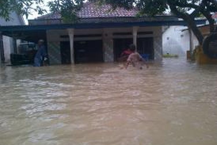 Warga berjalan ditengah banjir di Desa Mojo, Pemalang, Jawa Tengah, Selasa (28/01/2014). Banjir sendiri akibat sungai Comal yang meluap karena tidak bisa menampung volume air.
 