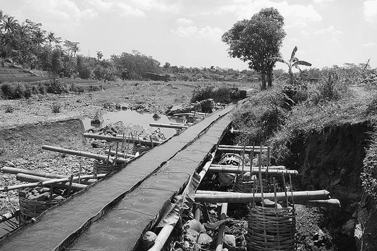 Seorang warga Desa Boja tengah membersihkan saluran irigasi Sungai Blorong di Dusun Pilang, Desa Boja, Kecamatan Boja, Kabupaten Kendal, Jawa Tengah, Selasa (6/9). Irigasi darurat yang terbuat dari potongan drum itu belum diperbaiki Pemerintah Kabupaten Kendal meskipun kerusakan saluran untuk 110 hektar sawah di sekitarnya ini  sudah terjadi sejak Januari 2011.