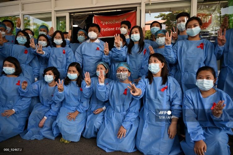 Staf medis memberi salam tiga jari dengan pita merah di seragam mereka di Rumah Sakit Umum Yangon, Myanmar, pada  Rabu (3/2/2021) ketika seruan untuk pembangkangan sipil semakin meningkat menyusul kudeta militer yang menahan pemimpin sipil Aung San Suu Kyi. 