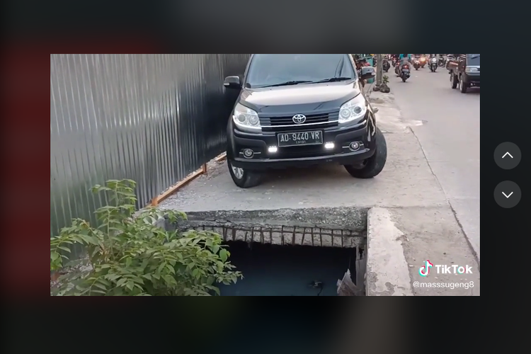 Tangkapan layar video viral parkir mobil di atas penutup selokan yang sempit