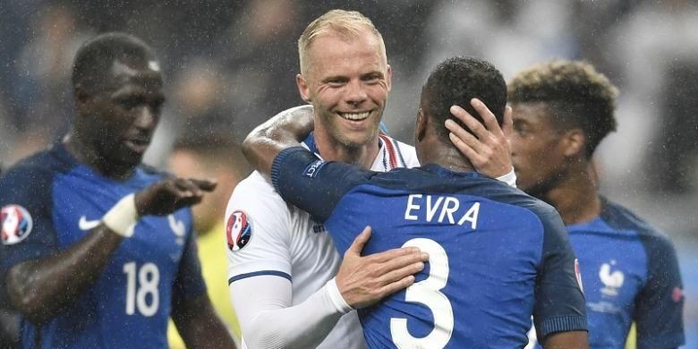 Pemain tim nasional Eslandia, Eidur Gudjohnsen, memeluk pemain Prancis, Patrice Evra, seusai laga perempat final Piala Eropa 2016 di Stade de France, 3 Juli 2016.
