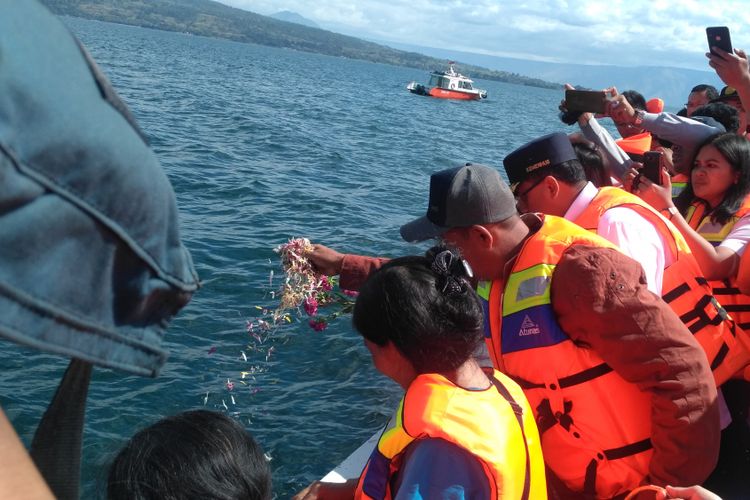 Menteri Perhubungan Budi Karya Sumadi melakukan prosesi tabur bunga bersama perwakilan keluarga korban tenggelamnya KM Sinar Bangun di Danau Toba, Simalungun, Sumatera Utara, Kamis (5/7/2018).