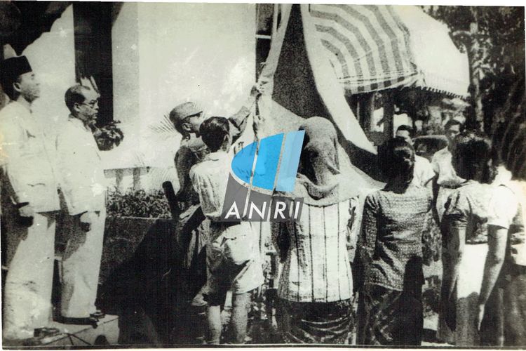 Pengibaran bendera merah putih usai pembacaan teks proklamasi kemerdekaan Republik Indonesia di rumah Soekarno di Jalan Pegangsaan Timur Nomor 56, Jakarta (sekarang Jalan Proklamasi Nomor 5, Jakarta Pusat) pada 17 Agustus 1945.