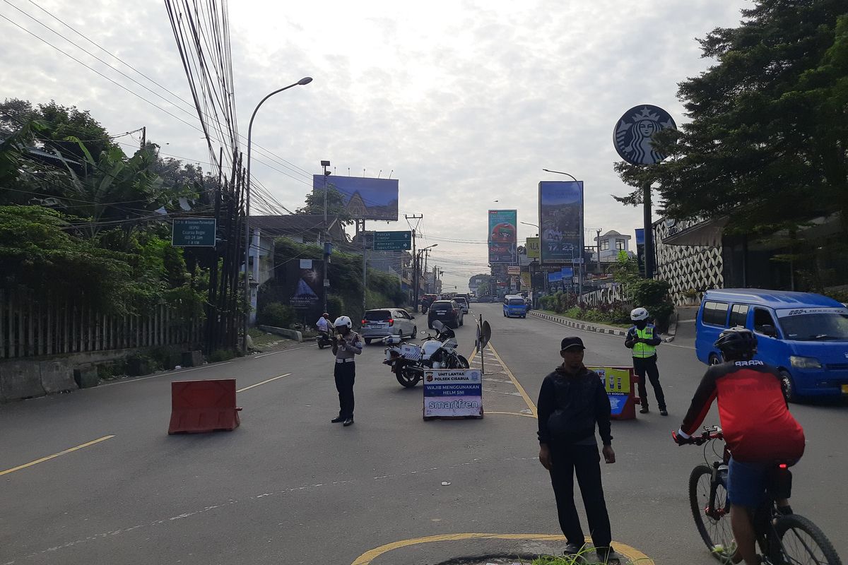 Petugas gabungan menerapkan kebijakan pembatasan lalu lintas dengan sistem ganjil genap diberlakukan di ruas Jalan Raya Puncak, Bogor, Jawa Barat, pada Kamis (29/5/2025).
