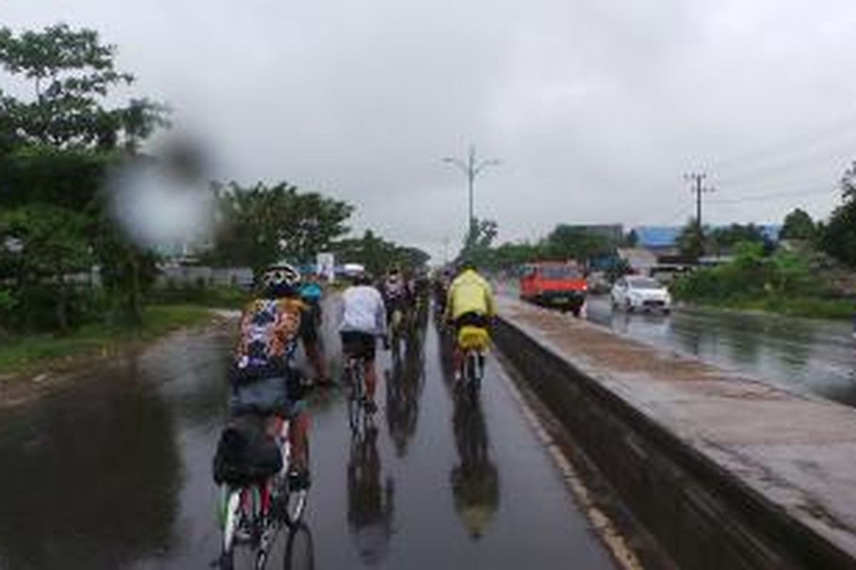 Para peserta Jelajah Sepeda Kompas Banjarmasin-Balikpapan bersepeda di tengah hujan pada Etape 1 Banjarmasin-Rantau, Senin (4/5/2015). Jelajah Sepeda Kompas Banjarmasin-Balikpapan berlangsung dari 4-10 Mei 2015.
