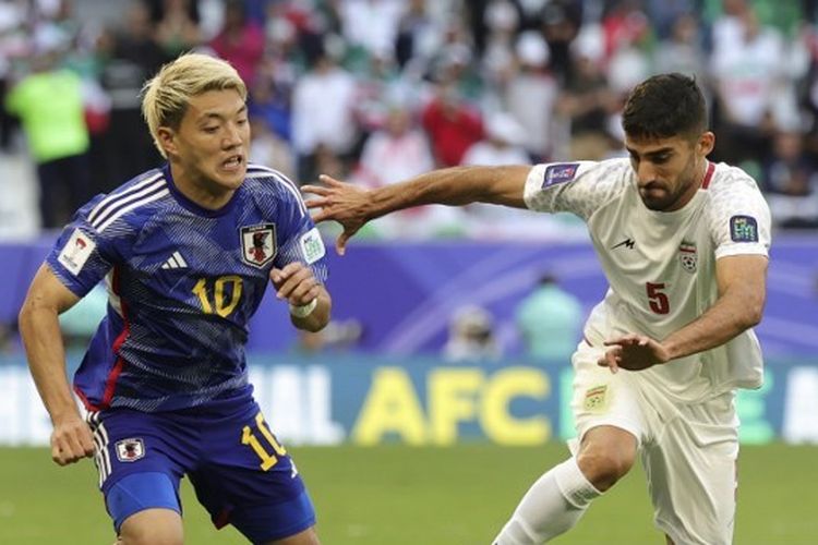 Bek Iran, Milad Mohammadi, berlari melewati pemain Jepang, Ritsu Doan, dalam perempat final Piala Asia 2023 antara Iran vs Jepang di Stadion Education City pada 3 Februari 2024.