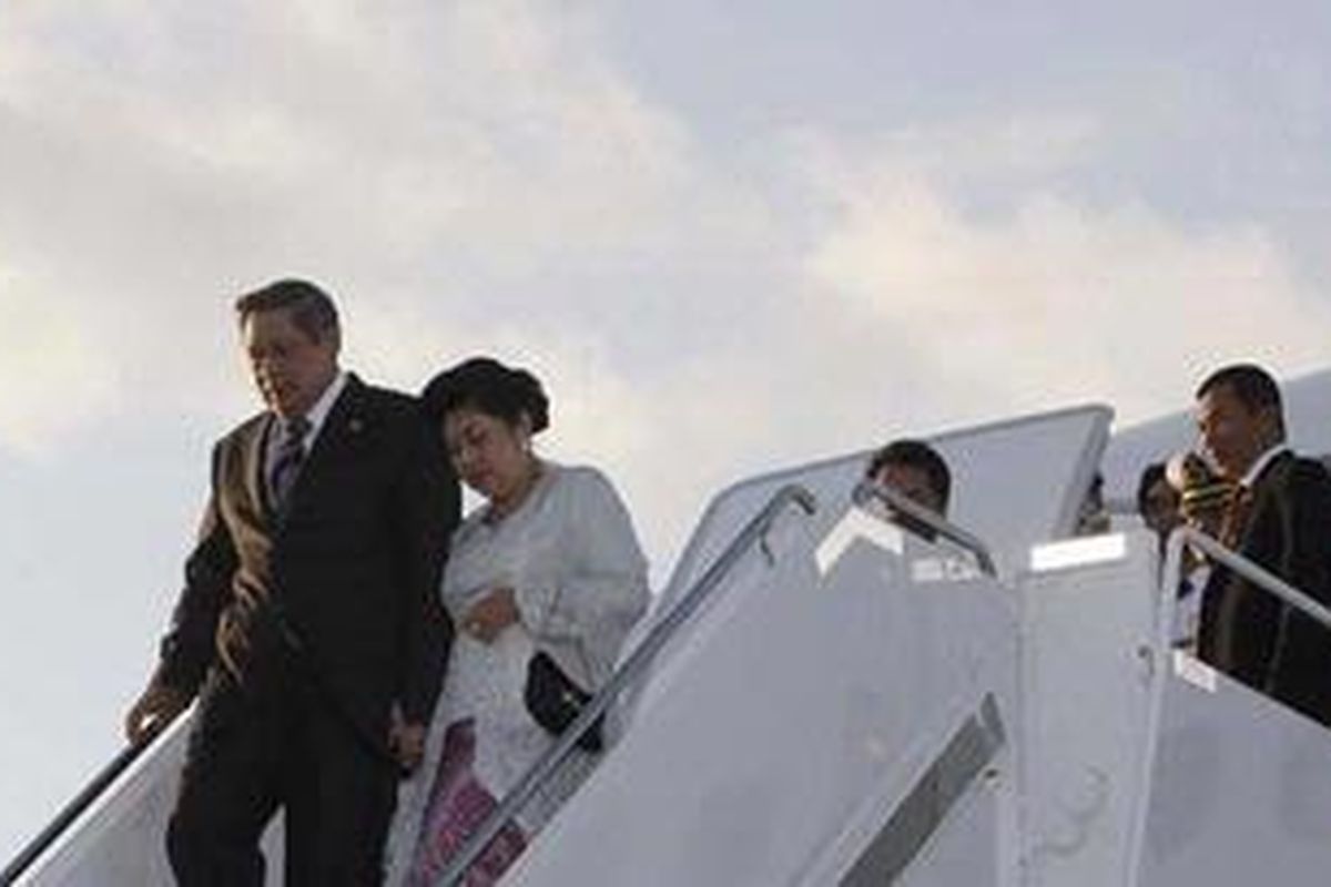 Ilustrasi Presiden Susilo Bambang Yudhoyono dan Ibu Negara Ani Yudhoyono menuruni tangga pesawat.