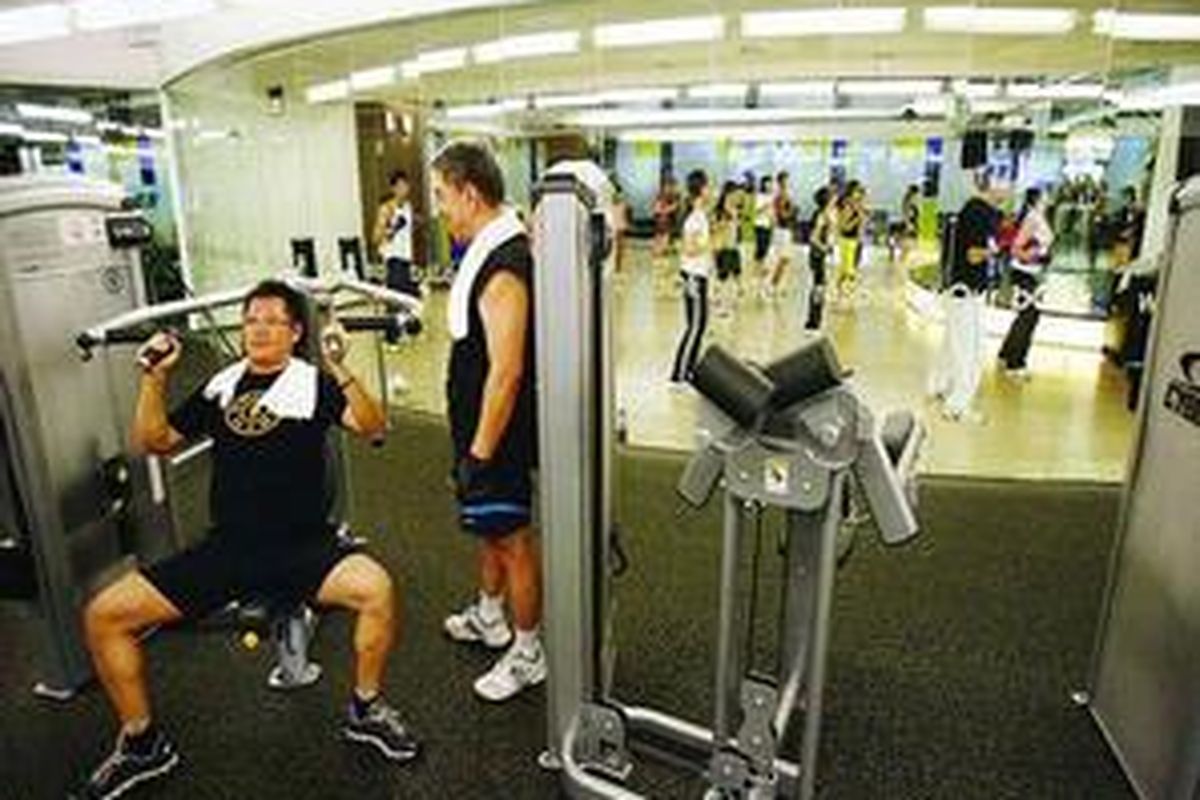 Anggota klubkebugaran berlatih beban dan mengikuti gerakan dalam kelas body combat di Gold s Gym, Mall Ciputra, Jakarta Barat, Jumat (11/9).