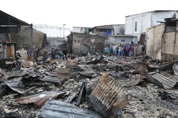 Warga melihat sisa-sisa puing rumah di Kampung Tanah Merah usai kebakaran Depo Pertamina Plumpang, Koja, Jakarta Utara, Sabtu (4/3/2023). Kebakaran ini mengakibatkan 17 orang meninggal dunia dan 51 orang luka-luka.