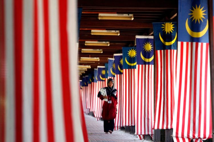 Seorang mahasiswa Universitas Nasional Malaysia berjalan melewati jajaran bendera nasional Malaysia di luar Kuala Lumpur 22 Agustus 2007.