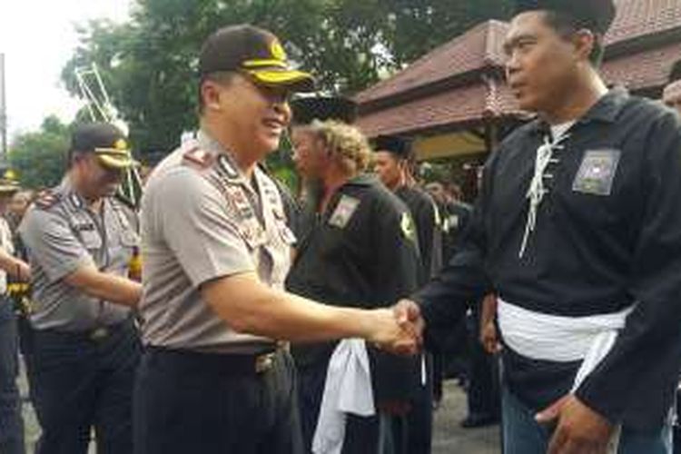 Kapolresta Madiun, AKBP Susatyo Purnomo Condro bersalaman dengan pesilat seusai menjadi irup gladi bersih pengamanan Suran Agung 2016 di halaman Mapolresta Madiun Kota, Jumat (14/10/2016).