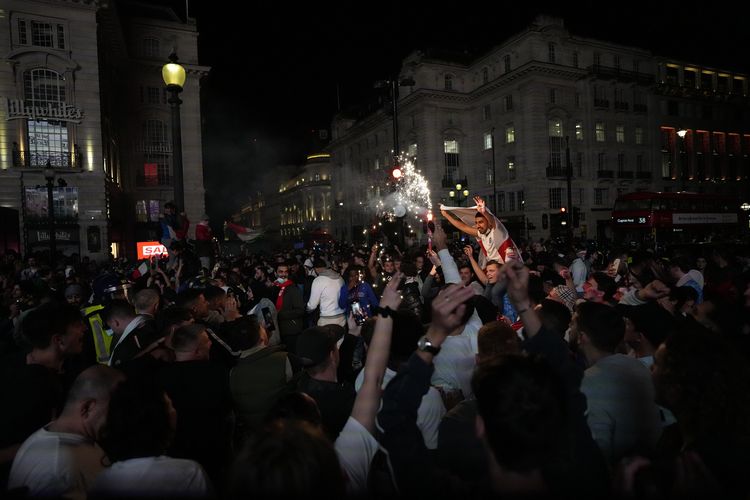 Suporter Italia merayakan kemenangan Gli Azzurri di Piccadilly Circus, London, Minggu (11/7/2021), setelah menjuarai Euro 2020 dengan mengalahkan Inggris via adu penalti di Stadion Wembley.