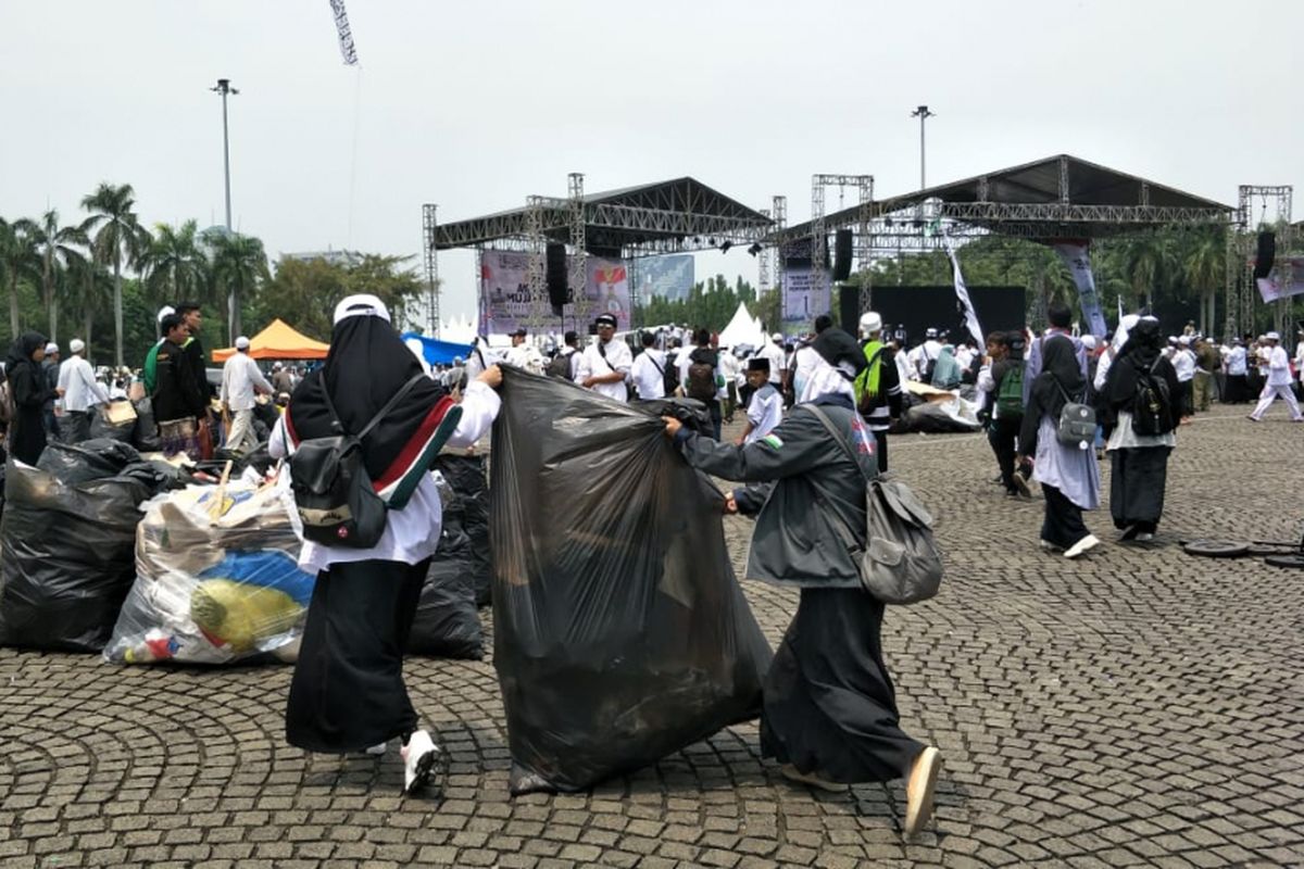 Sejumlah peserta Reuni 212 berinisiatif mengumpulkan sampah di kawasan Monas, Jakarta Pusat, setelah acara tersebut berakhir, Minggu (2/12/2018) siang.
