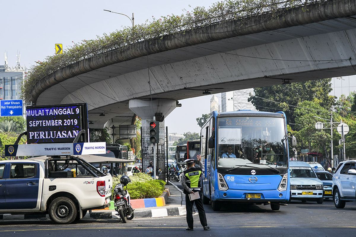 Petugas kepolisian mengatur lalulintas saat hari pertama penindakan sistem ganjil-genap di kawasan Matraman, Jakarta, Senin (9/9/2019). Petugas kepolisian mulai memberlakukan penindakan berupa tilang terhadap pengendara mobil yang melanggar di kawasan perluasan sistem ganjil-genap. ANTARA FOTO/Galih Pradipta/foc.